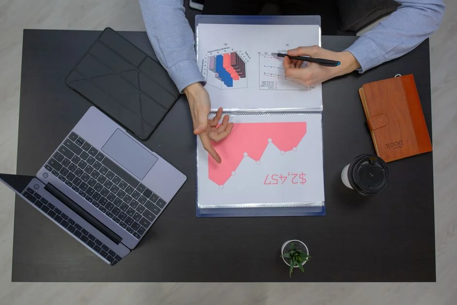 Bird’s-eye view of a diverse team reviewing marketing strategies with charts and graphs.